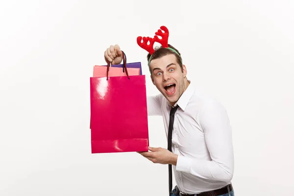 Boże Narodzenie Concept - Przystojny Biznes człowiek świętować Wesołych Świąt i szczęśliwego Nowego Roku nosić reniferów opaskę i trzymając Santa czerwony big bag. — Zdjęcie stockowe