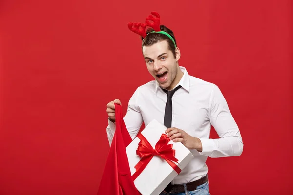 Weihnachts-Konzept - Schöner Geschäftsmann feiern frohe Weihnachten und ein glückliches neues Jahr tragen Rentier Haarband hält Santa roten Big Bag. — Stockfoto