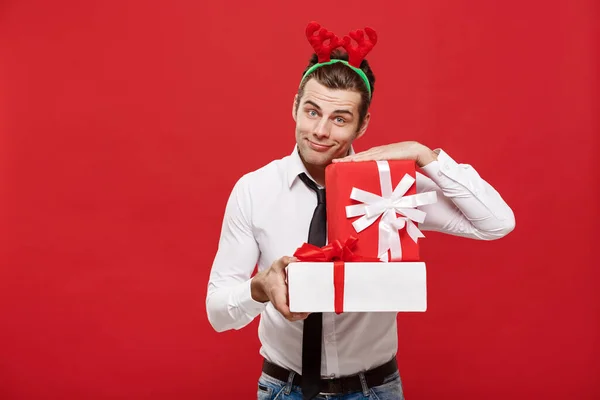 圣诞概念-快乐快乐的年轻商人，带着红色背景的装饰礼物. — 图库照片