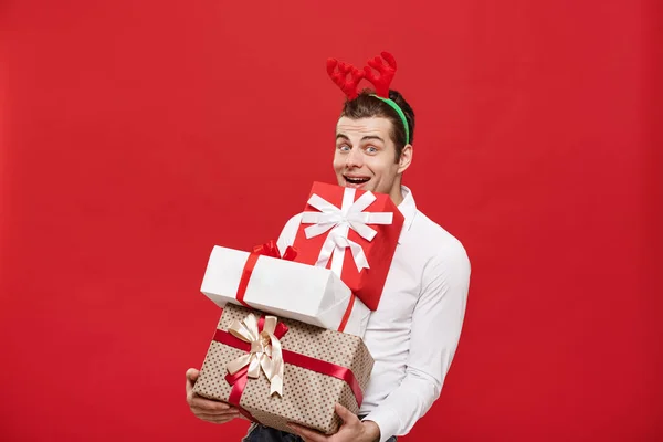 圣诞观念-英俊的高加索快乐商人，拥有许多礼物，头戴圣诞礼帽，头戴白色孤立的背景. — 图库照片