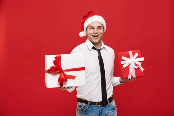Christmas Concept - Porträt glücklicher Weihnachtsmann Geschäftsmann begeistert mit seinem Geschenk vor rotem Hintergrund. — Stockfoto