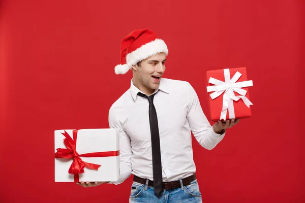 Christmas Concept - Porträt glücklicher Weihnachtsmann Geschäftsmann begeistert mit seinem Geschenk vor rotem Hintergrund. — Stockfoto