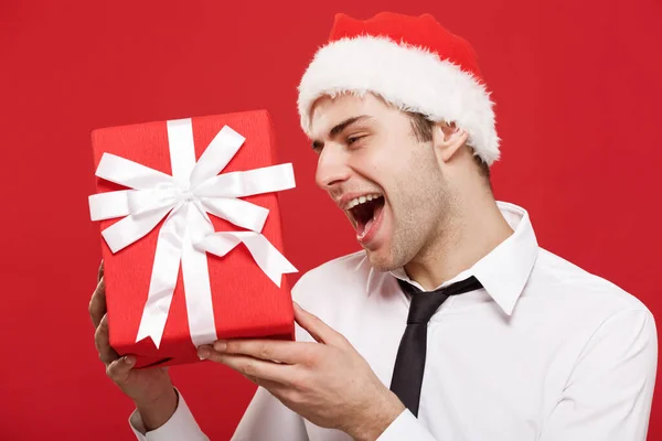 Conceito de Natal - retrato close-up Papai Noel homem de negócios sobre fundo vermelho segurando presente vermelho . — Fotografia de Stock