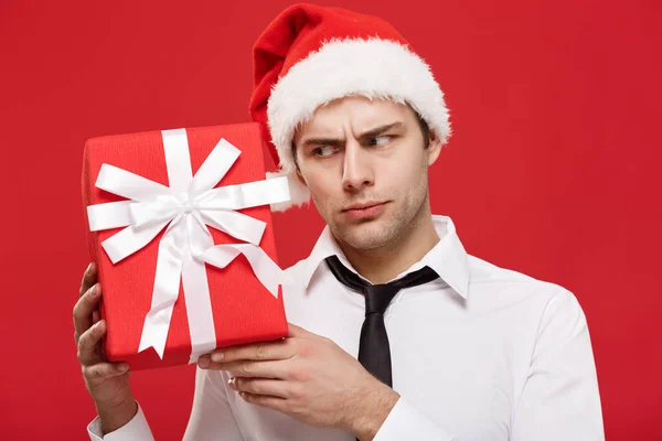 Conceito de Natal - retrato close-up Papai Noel homem de negócios sobre fundo vermelho segurando presente vermelho . — Fotografia de Stock