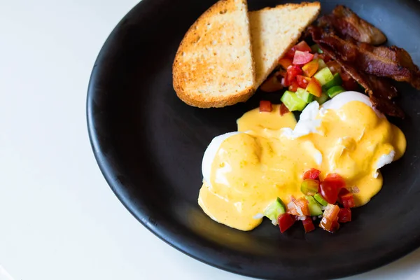 Uova Benedict - pane, becon e pomodoro, uova in camicia e deliziosa salsa olandese burrosa — Foto Stock