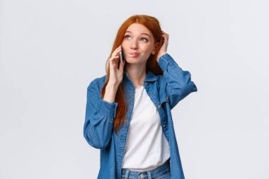 Kararsız kızıl saçlı kızın sorunlu olması, telefonda konuşması, kararsız ve bilgisiz durması, kafası karışmış kaşınması, sırıtması ve akıllı telefon araması gibi düşünceli bakışlar atması.