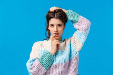 Belden yukarısı, şehvetli ve kadınsı bir kadın birini baştan çıkarmak ister. Gözlerini kısarak flört eden, cilveli bakışlar atan, dudaklarını okşayan, mavi arka planda seksi pozlar veren bir kadın.