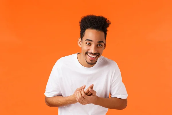 Lebensstil, moderne Menschen, Emotionen. Glücklich schöner junger afrikanisch-amerikanischer Mann mit Schnurrbart und Afro-Frisur, lachende klatschende Hände, gute Laune, gutes Gefühl, orangefarbener Hintergrund — Stockfoto