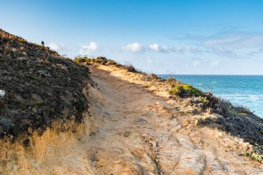 Atlantik Okyanusu kıyısı - Rota Vicentina yürüyüş işareti, Aljezur, Portekiz 'deki vahşi plajlar ve uçurumlar