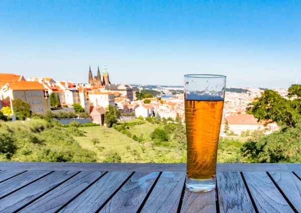 Prag Kalesi ve Prag 'daki Aziz Vitus Katedrali' nin manzarasına karşı bir bardak bira. Çek Cumhuriyeti. Panoramik görünüm.