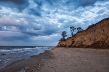 Havası düşük bulutlar ve dalgalarla dramatik deniz kıyıları. Odessa, Ukrayna 'da yüksek çamurlu sahili olan Karadeniz plajı.