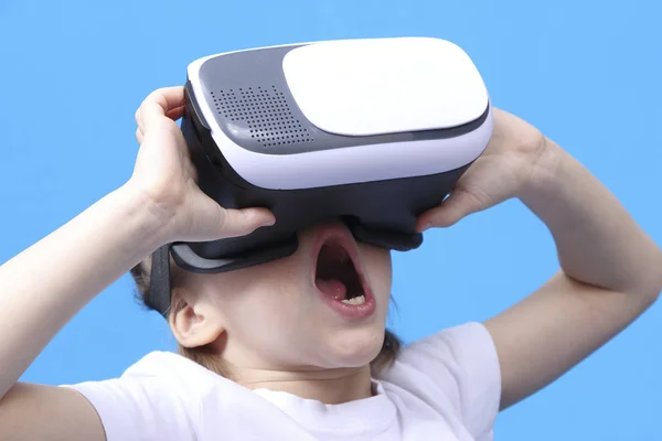 Дівчина кричить у окулярах віртуальної реальності. ізольовані на синьому фоні — стокове фото