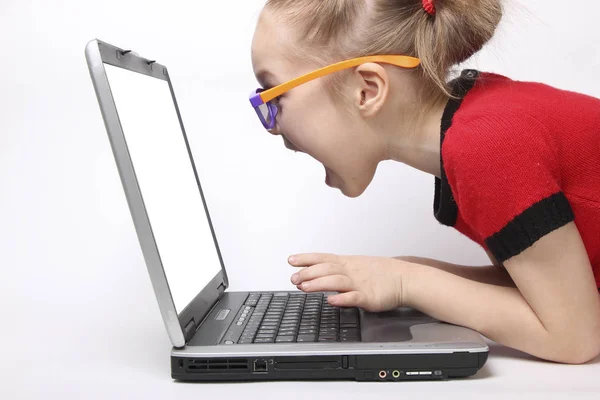 Mädchen ist schockiert und schreit vor dem Laptop-Bildschirm. isolierter weißer Hintergrund. Orangefarbene Gläser — Stockfoto