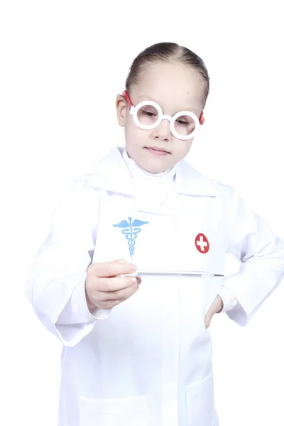 Little girl in the form of doctor looks at the thermometer — Stock Photo, Image