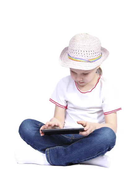 Mała dziewczynka gra na tablet na białym tle — Zdjęcie stockowe