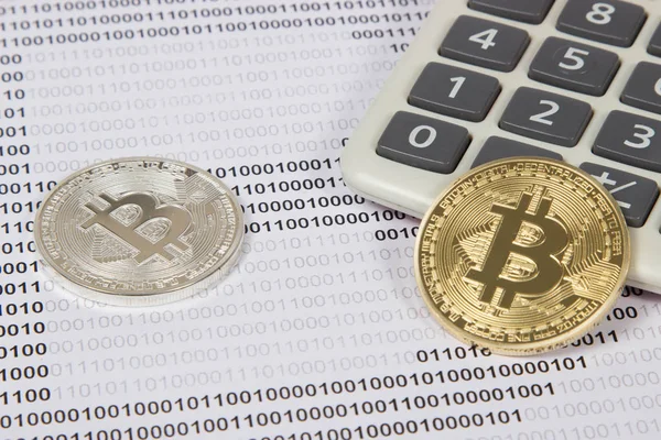 Altın ve gümüş bitcoin beyaz Hesap makinesinde yatıyor
