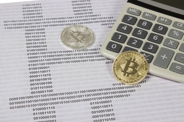 Altın ve gümüş bitcoin beyaz Hesap makinesinde yatıyor Stok Fotoğraf