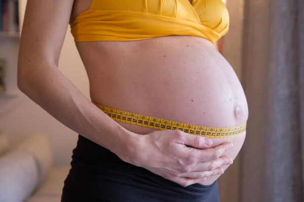Pancia di giovane donna incinta con metro a nastro. Salute prenatale — Foto Stock