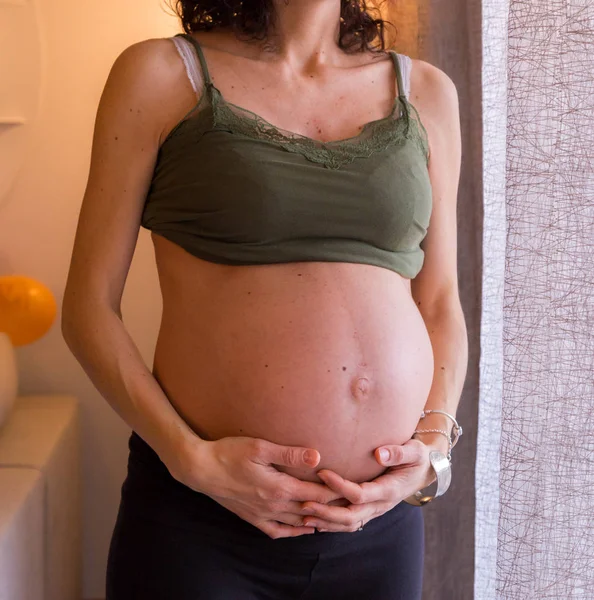 Donna incinta tiene le mani sul suo ventre gonfio. Maternità — Foto Stock