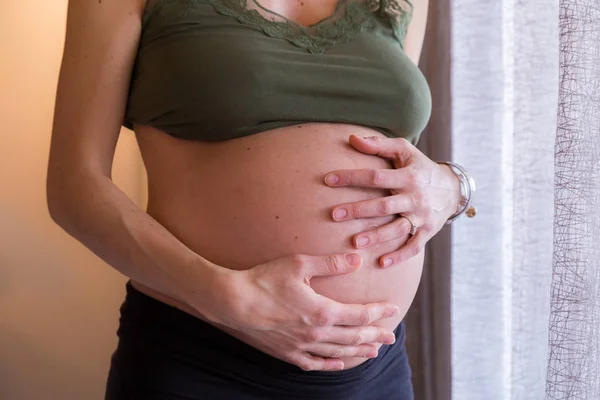 La joven embarazada sostiene sus manos sobre su vientre hinchado. Lovin. — Foto de Stock