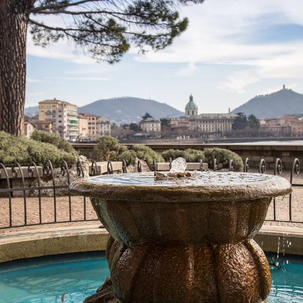 Vodní fontána před romantický výhled na panoráma města Como — Stock fotografie