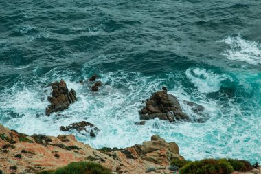 Dalgalar üzerinde Sardunyalı kıyılarının cliff taş knock