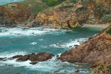 Dalgalar üzerinde Sardunyalı kıyılarının cliff taş knock