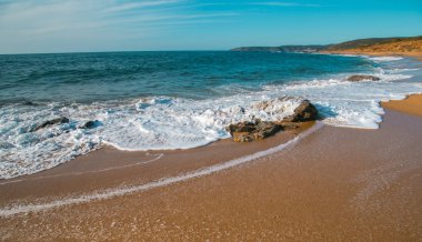 Rock ve güneşli bir gün dalgalarda. Sardunya