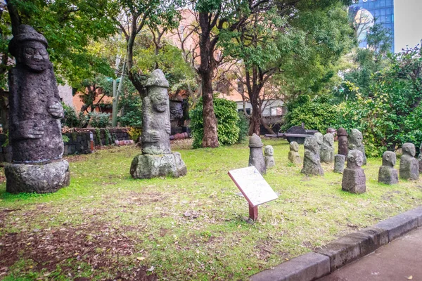 Grupo de ídolos de piedra (Dolharubang, las "piedras del abuelo") en Jeju Mokgwana, el edificio restante más antiguo de Jeju para la antigua oficina del gobierno central, donde el magistrado del período Joseon de Jeju de 1392 a 1910 —  Fotos de Stock