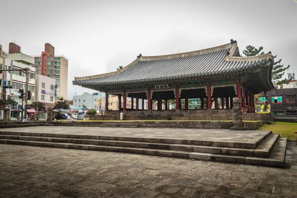 Pavillion och stenen idol (Dolharubang, "farfar stenarna") i närheten Jeju Mokgwana, den äldsta kvarvarande byggnad i Jeju för tidigare statliga kontor där den Joseon Period Magistrate Jeju från 1392 till 1910 — Stockfoto
