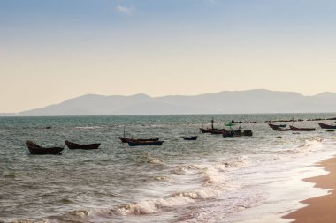 Güzel deniz, kum ve dağ ve mavi gökyüzü ile balıkçı tekneleri