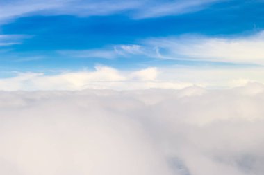 Güzel doğa gökyüzü hava görünümden. Yukarıda gökyüzü ve bulutlar doğa görünüm güzelliği. Beyaz bulutlar ve mavi gökyüzü uçak penceresinden görüntüleyin. Bulutların üstünde güneş gökyüzünde parlıyor.