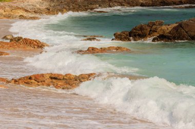 Güzel beyaz kabarcıklar sahilde okyanus dalgaları seashore tarafından yaratılmıştır. Okyanus dalgaları sahilde kayalara çarptı