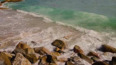 Güzel beyaz kabarcıklar sahilde okyanus dalgaları seashore tarafından yaratılmıştır. Okyanus dalgaları sahilde kayalara çarptı.