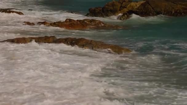 ビーチの海岸に海の波によって作成された美しい白い泡 海の波は ビーチで岩を打つ — ストック動画