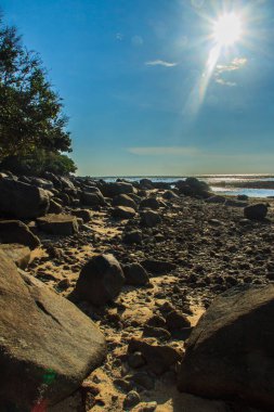 Güzel taş taş plaj deniz suyu dramatik mavi gökyüzü arka plan ile bulutlu gün çekildi..