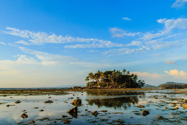 寂寞的海岛与岩石海滩和树当海水消退在蓝天和多云天背景 — 图库照片