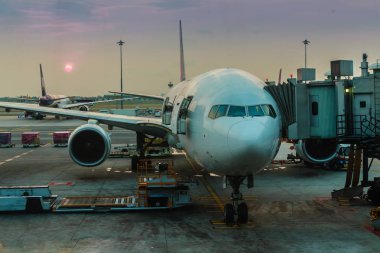 Uçak terminal kapısında modern uluslararası havaalanında kalkışa hazır. Bu sabahı yolcu panosuna hazırlama uçuş uçak ile havaalanında güzel gündoğumu.