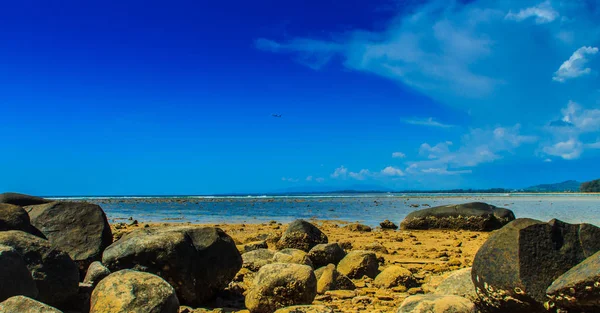 海滩上的美丽石头当海水退去的时候 阴天的蓝天背景 — 图库照片