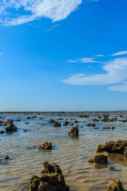 Güzel taş taş plaj deniz suyu dramatik mavi gökyüzü arka plan ile bulutlu gün çekildi..