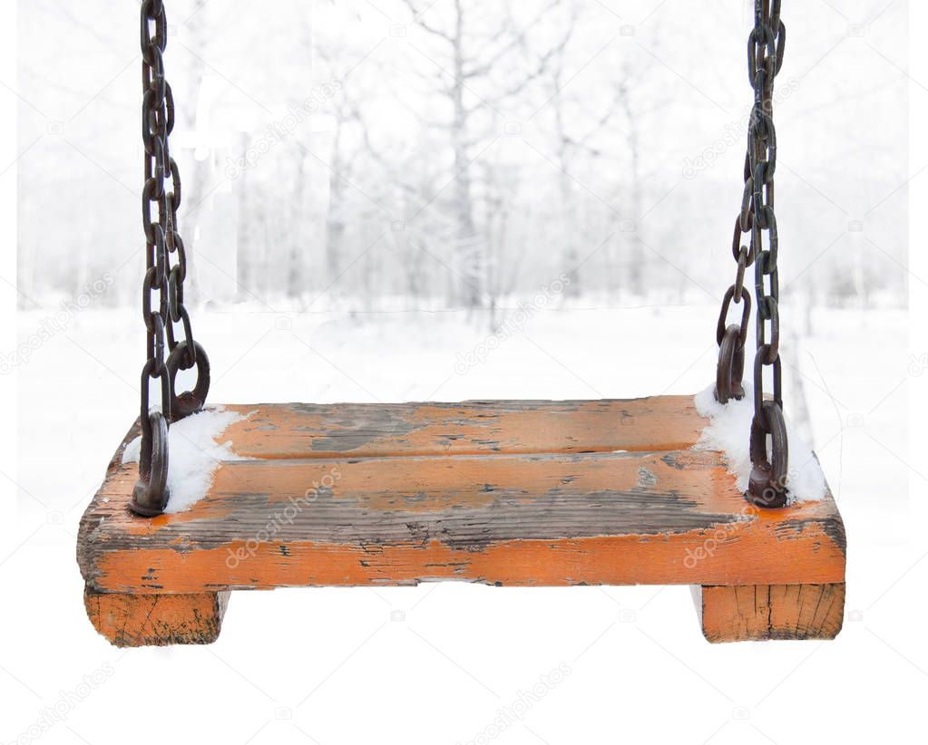 Orange wooden swing with metal chain suspension on the foreground