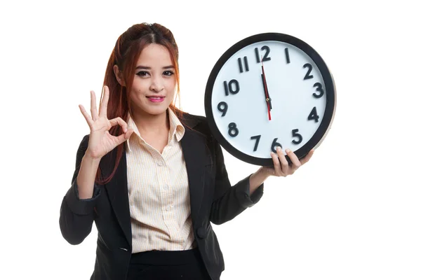 Young Asian business woman show OK with a clock. — Stock Photo, Image