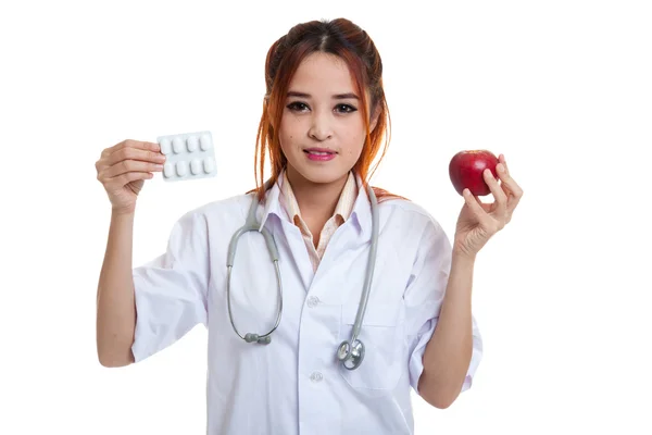 Junge asiatische Ärztin mit Pillen und Apfel. — Stockfoto