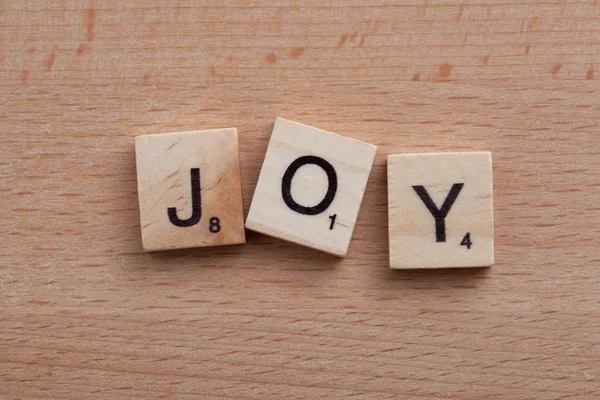 Scrabble letters spelling the word Joy. — Stock Photo, Image