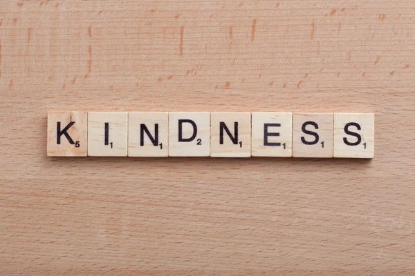 Scrabble letras soletrando a palavra bondade . — Fotografia de Stock