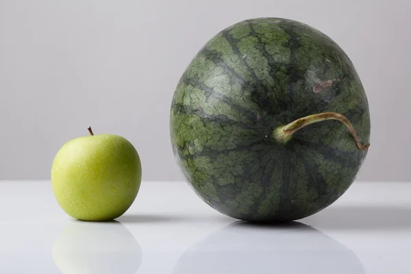 Grootte van water meloen vergelijken met groene appel — Stockfoto