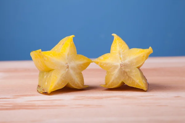 Mezzo taglio di starfruit su tavolo di legno — Foto Stock