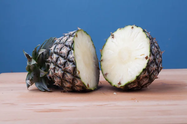 De helft knippen van ananas op houten tafel — Stockfoto