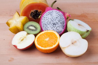 Yarım kesim üzerinde ahşap masa meyve karışımı