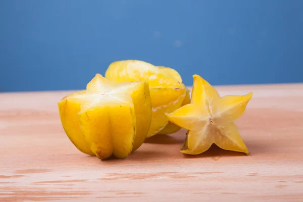 Metade de corte de starfruit na mesa de madeira — Fotografia de Stock